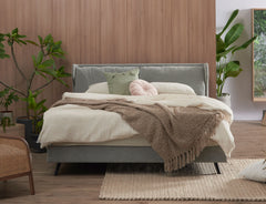 Winged bed frame displayed from a wider angle